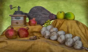 Martwa natura przykłady: czosnek, granaty, cytryny, młynek do kawy i miech.