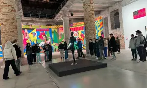 Grupa zwiedzających ogląda barwne instalacje w galerii. To właśnie jest biennale – świat sztuki w pigułce.