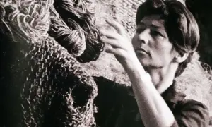 Magdalena Abakanowicz z dłońmi wśród swoich monumentalnych, plecionych dzieł, abakanów.