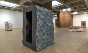 Kamienna rzeźba z czarnym wnętrzem, część wystawy Anish Kapoor w Orońsku. W tle inne dzieła sztuki.