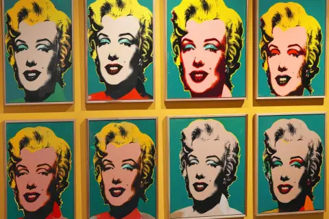 Osiem portretów Marilyn Monroe w stylu pop art Warhol, z różnymi kolorami tła i makijażu.