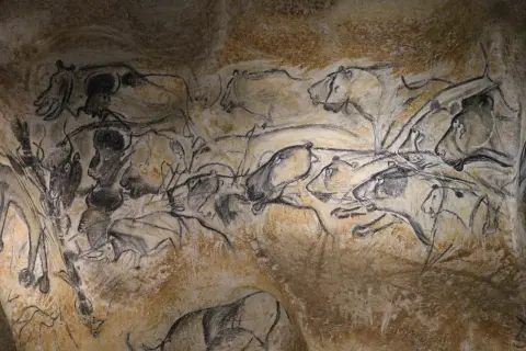 Prehistoryczne malarstwo abstrakcyjne na ścianie jaskini przedstawia dynamiczne sceny z udziałem zwierząt, jakby uchwycone w ruchu.