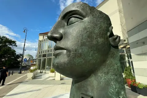 Monumentalna głowa z brązu, jedno z dzieł Igora Mitoraja, góruje nad miejskim placem.