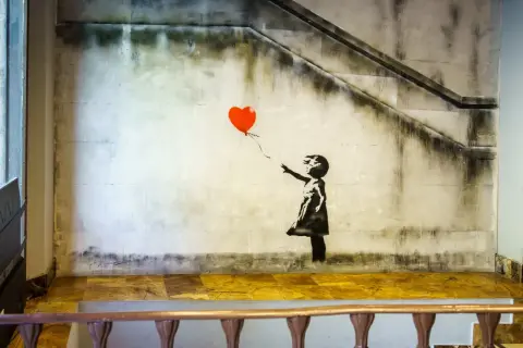 Dziewczynka z balonikiem znaczenie: Banksy'ego dzieło przedstawia dziewczynkę puszczającą czerwony balon w kształcie serca.