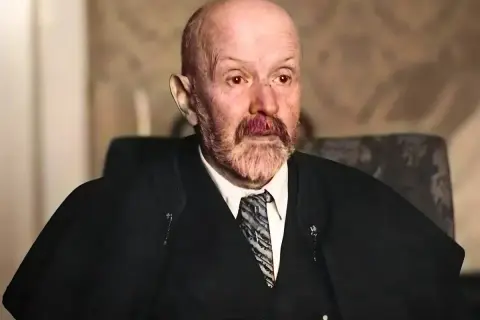 Portret starszego mężczyzny z siwą brodą i wąsami, w garniturze i krawacie. Jego spojrzenie jest intensywne, jakby uchwycone w chwili głębokiej refleksji nad rzeczywistością. Malczewski w swoim żywiole.