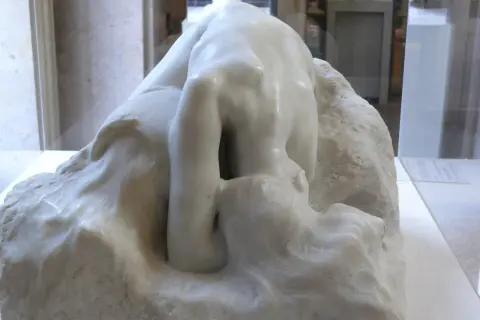 Kamienna postać pochylona w głębokiej zadumie, jak Auguste Rodin Myśliciel, wpatruje się w otchłań własnych myśli.