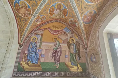 Mozaika przedstawia scenę z życia Maryi i anioła, ozdobiona motywami sztuki sakralnej.