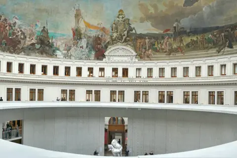Wnętrze Bourse de Commerce w Paryżu, z freskami na kopule i nowoczesną spiralną rampą. Może to być miejsce, gdzie François Pinault prezentuje swoje kolekcje sztuki.