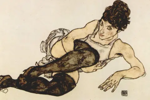 Ekspresyjne dzieła Egona Schiele: kobieta w pończochach leży w prowokacyjnej pozie, jej ciało wygięte w nienaturalny sposób.