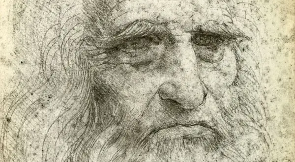 Szkic przedstawia zmęczoną twarz, prawdopodobnie autoportret Leonardo da Vinci, z charakterystyczną brodą i zmarszczkami.