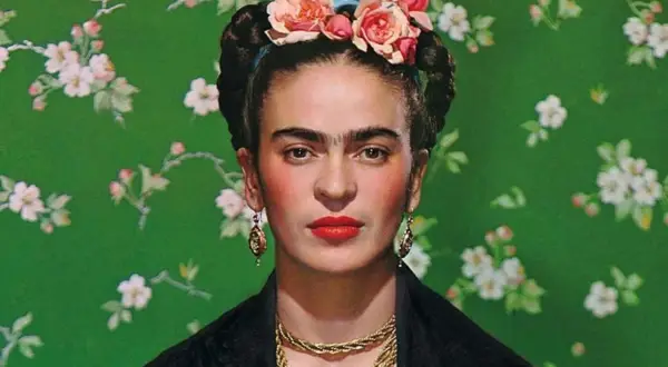 Frida Kahlo, symbol siły mimo niepełnosprawności, w kwiecistej opasce i z wyrazistym spojrzeniem.