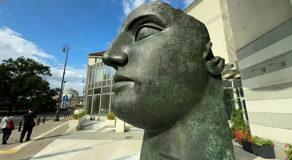 Monumentalna głowa z brązu, jedno z dzieł Igora Mitoraja, góruje nad miejskim placem.