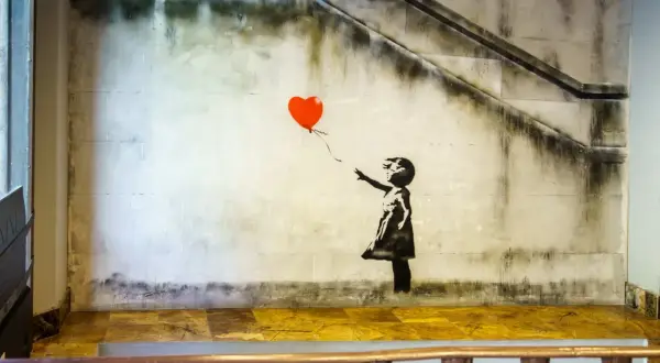 Dziewczynka z balonikiem znaczenie: Banksy'ego dzieło przedstawia dziewczynkę puszczającą czerwony balon w kształcie serca.
