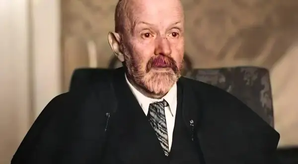 Portret starszego mężczyzny z siwą brodą i wąsami, w garniturze i krawacie. Jego spojrzenie jest intensywne, jakby uchwycone w chwili głębokiej refleksji nad rzeczywistością. Malczewski w swoim żywiole.