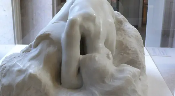 Kamienna postać pochylona w głębokiej zadumie, jak Auguste Rodin Myśliciel, wpatruje się w otchłań własnych myśli.