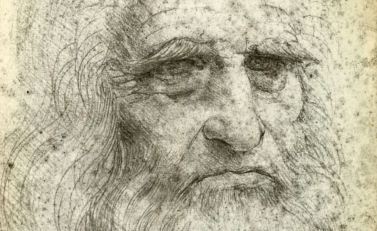 Szkic przedstawia zmęczoną twarz, prawdopodobnie autoportret Leonardo da Vinci, z charakterystyczną brodą i zmarszczkami.