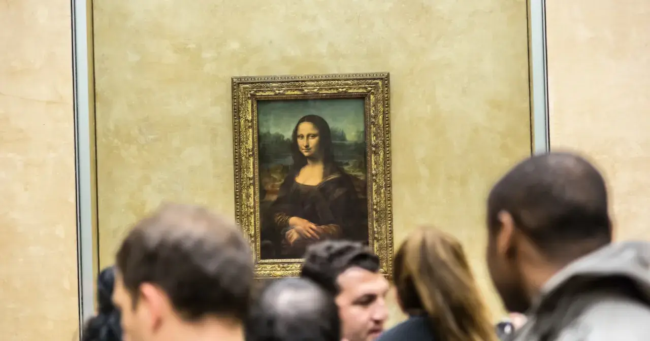 Słynny obraz Mona Lisa da Vinci, otoczony tłumem widzów w muzeum.