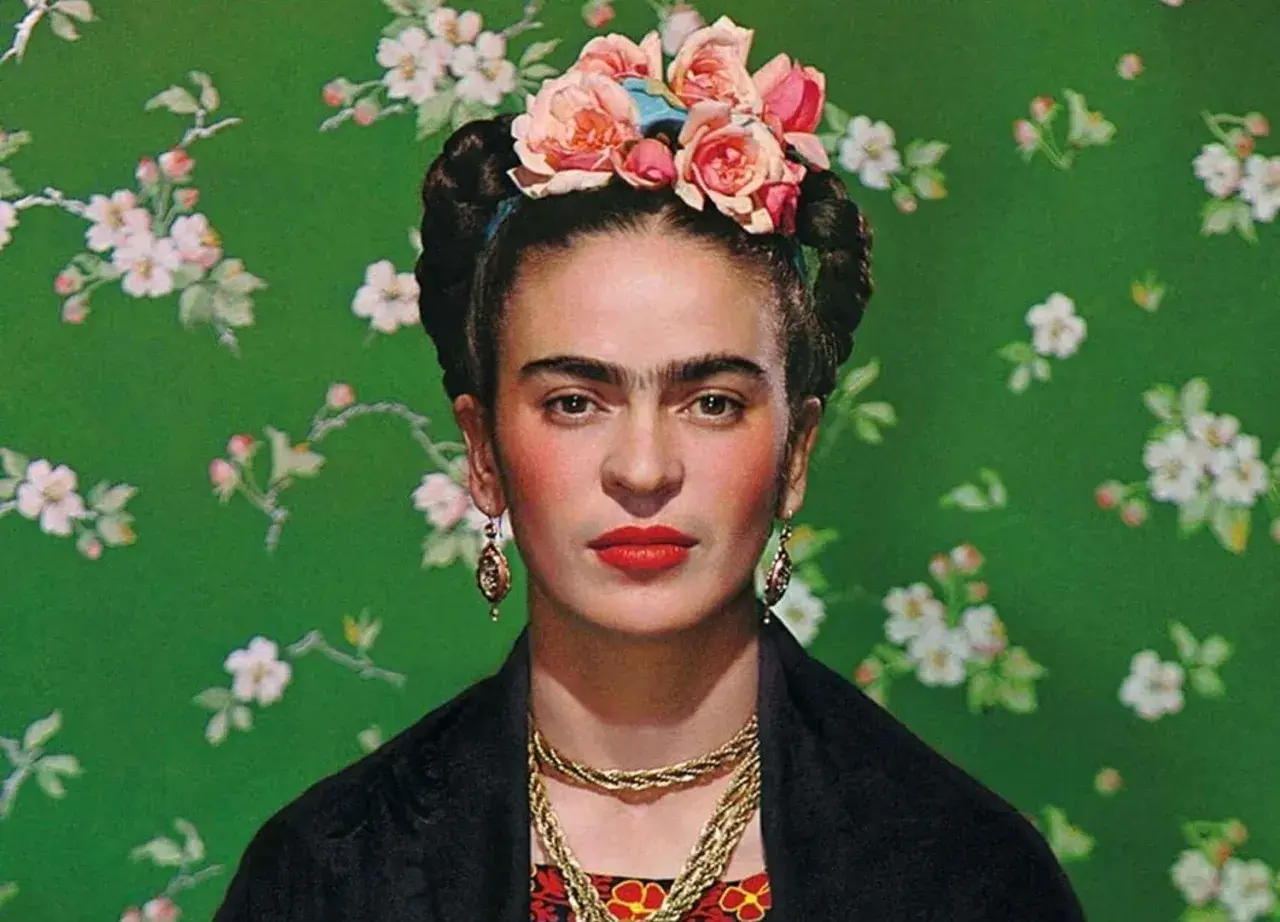 Frida Kahlo, symbol siły mimo niepełnosprawności, w kwiecistej opasce i z wyrazistym spojrzeniem.