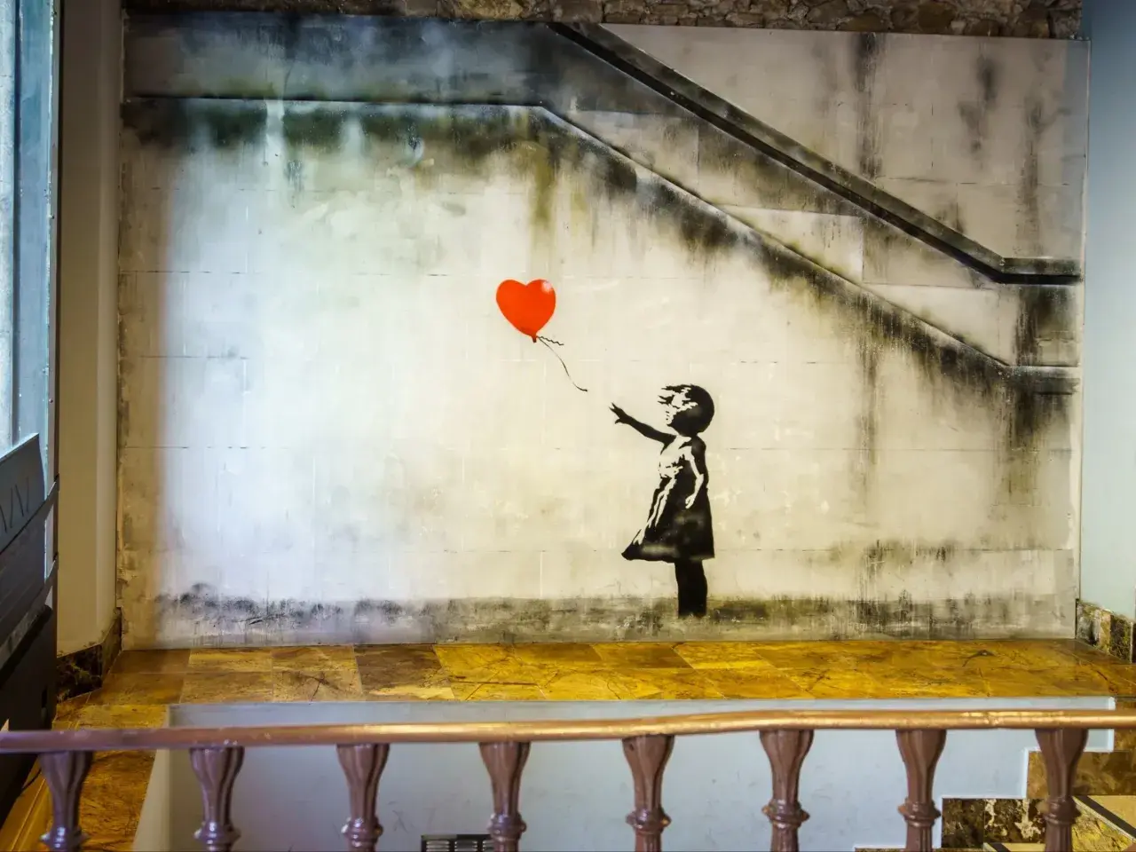 Dziewczynka z balonikiem znaczenie: Banksy'ego dzieło przedstawia dziewczynkę puszczającą czerwony balon w kształcie serca.