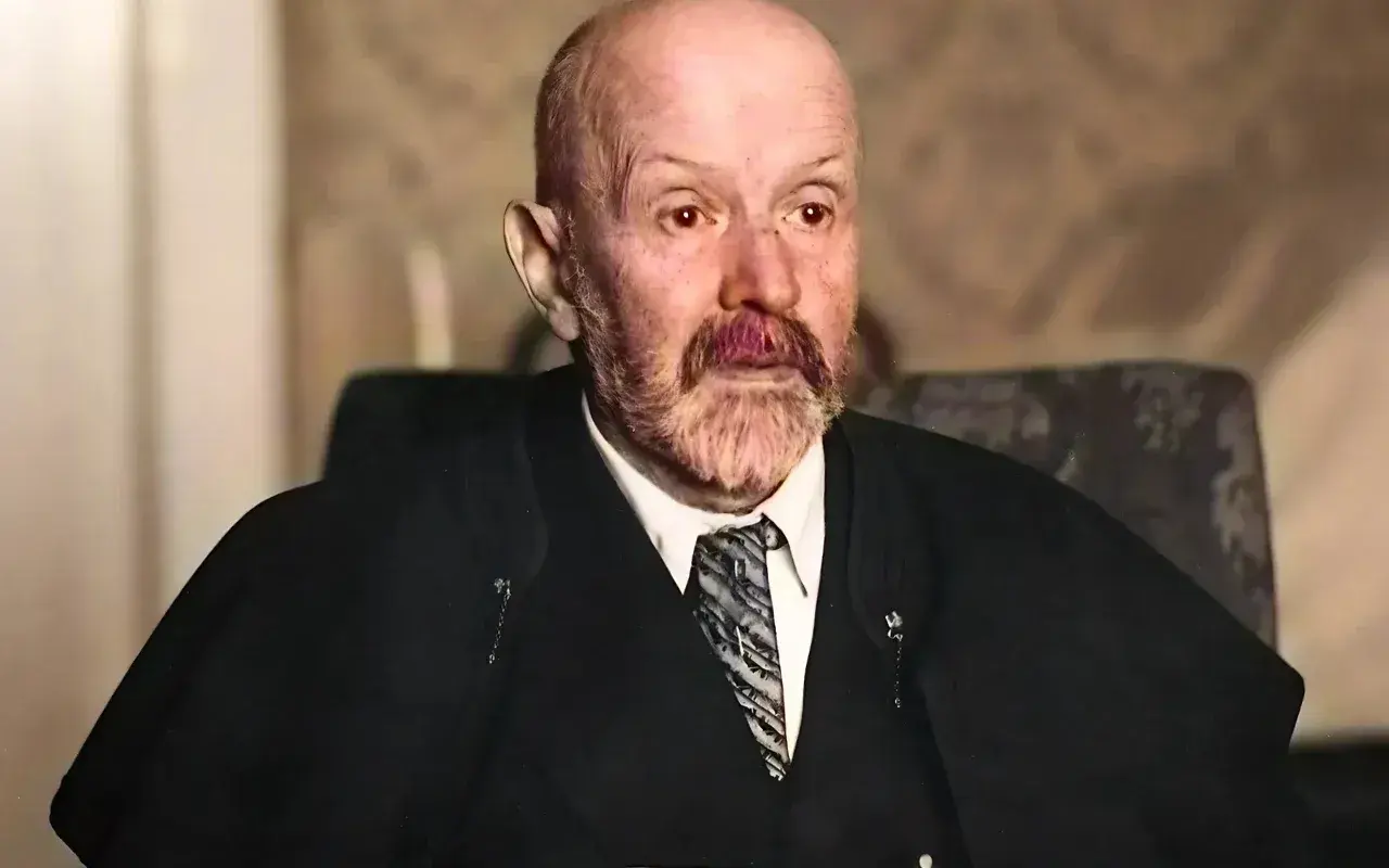 Portret starszego mężczyzny z siwą brodą i wąsami, w garniturze i krawacie. Jego spojrzenie jest intensywne, jakby uchwycone w chwili głębokiej refleksji nad rzeczywistością. Malczewski w swoim żywiole.
