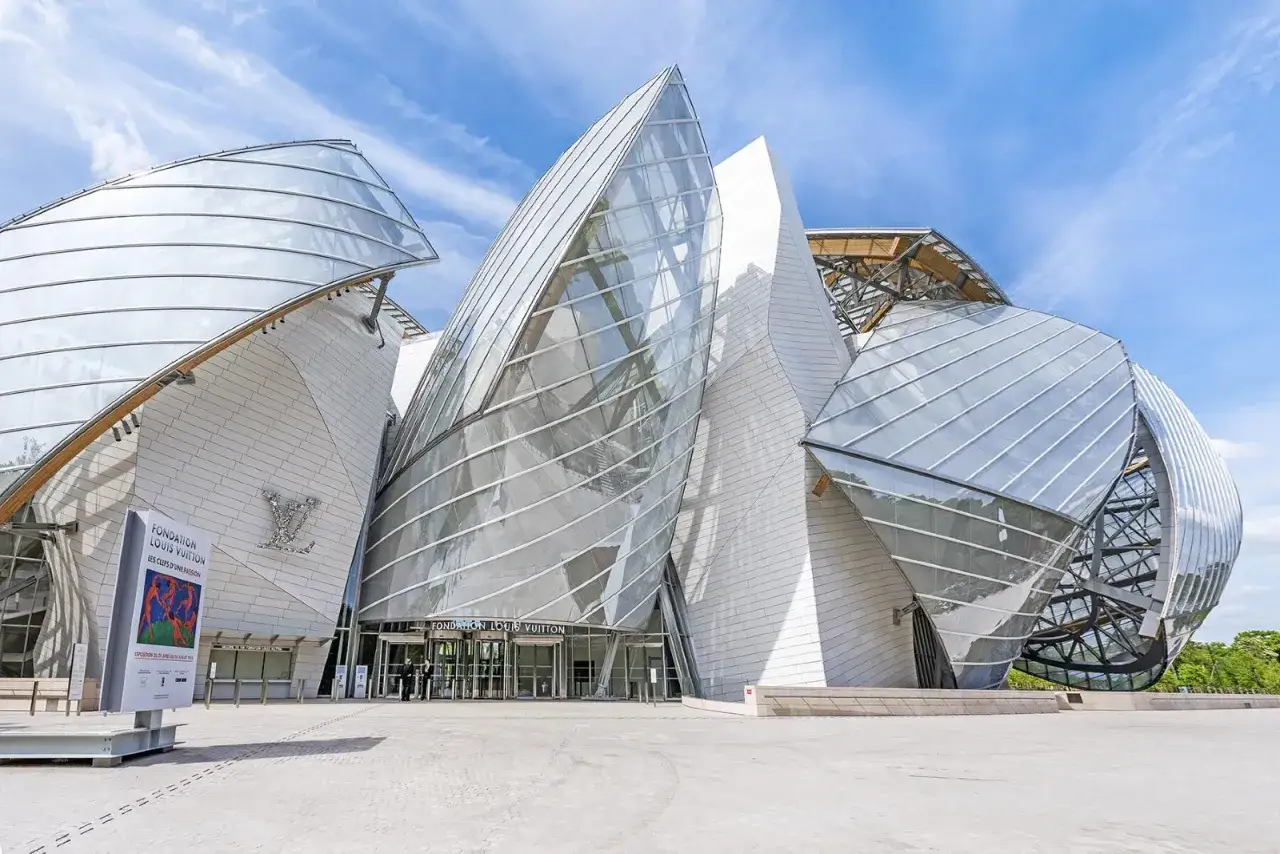 Nowoczesna architektura Fundacji Louis Vuitton, z falującymi szklanymi żaglami i białymi panelami, przyciąga wzrok.