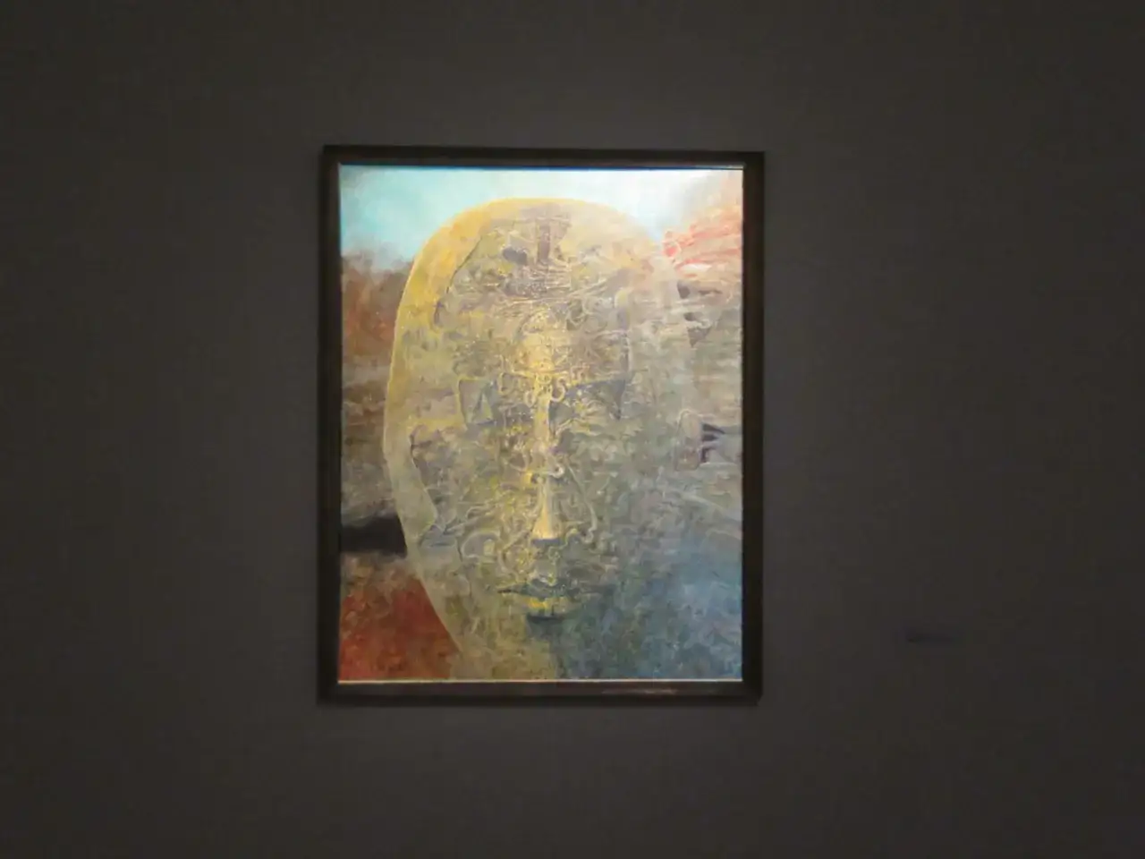 Beksiński ostatni obraz: surrealistyczna twarz, pełna detali i symboli, w odcieniach żółci, błękitu i czerwieni.