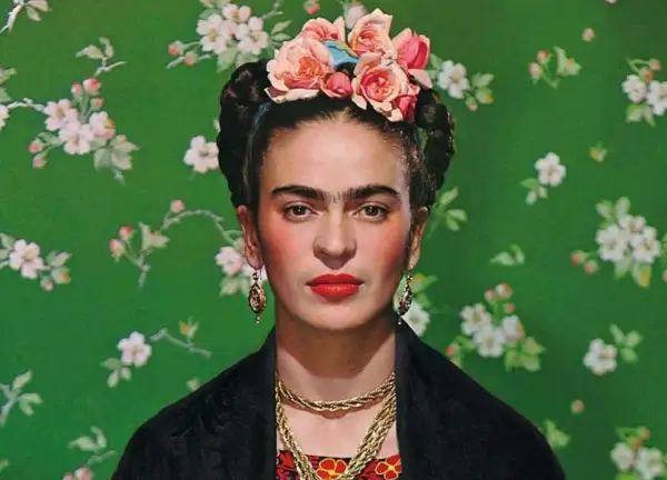 Frida Kahlo, symbol siły mimo niepełnosprawności, w kwiecistej opasce i z wyrazistym spojrzeniem.