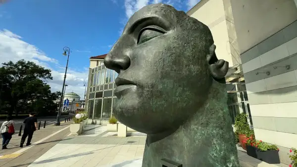 Monumentalna głowa z brązu, jedno z dzieł Igora Mitoraja, góruje nad miejskim placem.