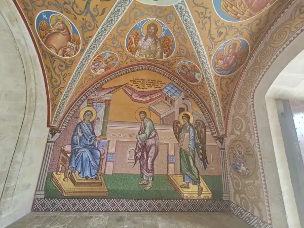 Mozaika przedstawia scenę z życia Maryi i anioła, ozdobiona motywami sztuki sakralnej.